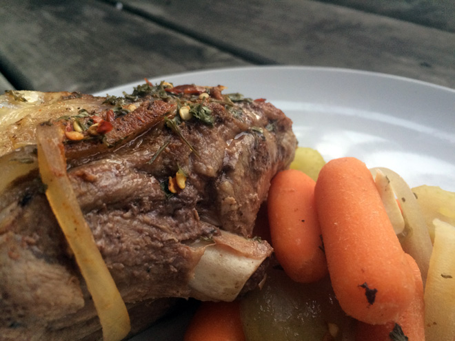 Slow-cooker goat roast with carrots, onion, celery, garlic, broth, and herbs.